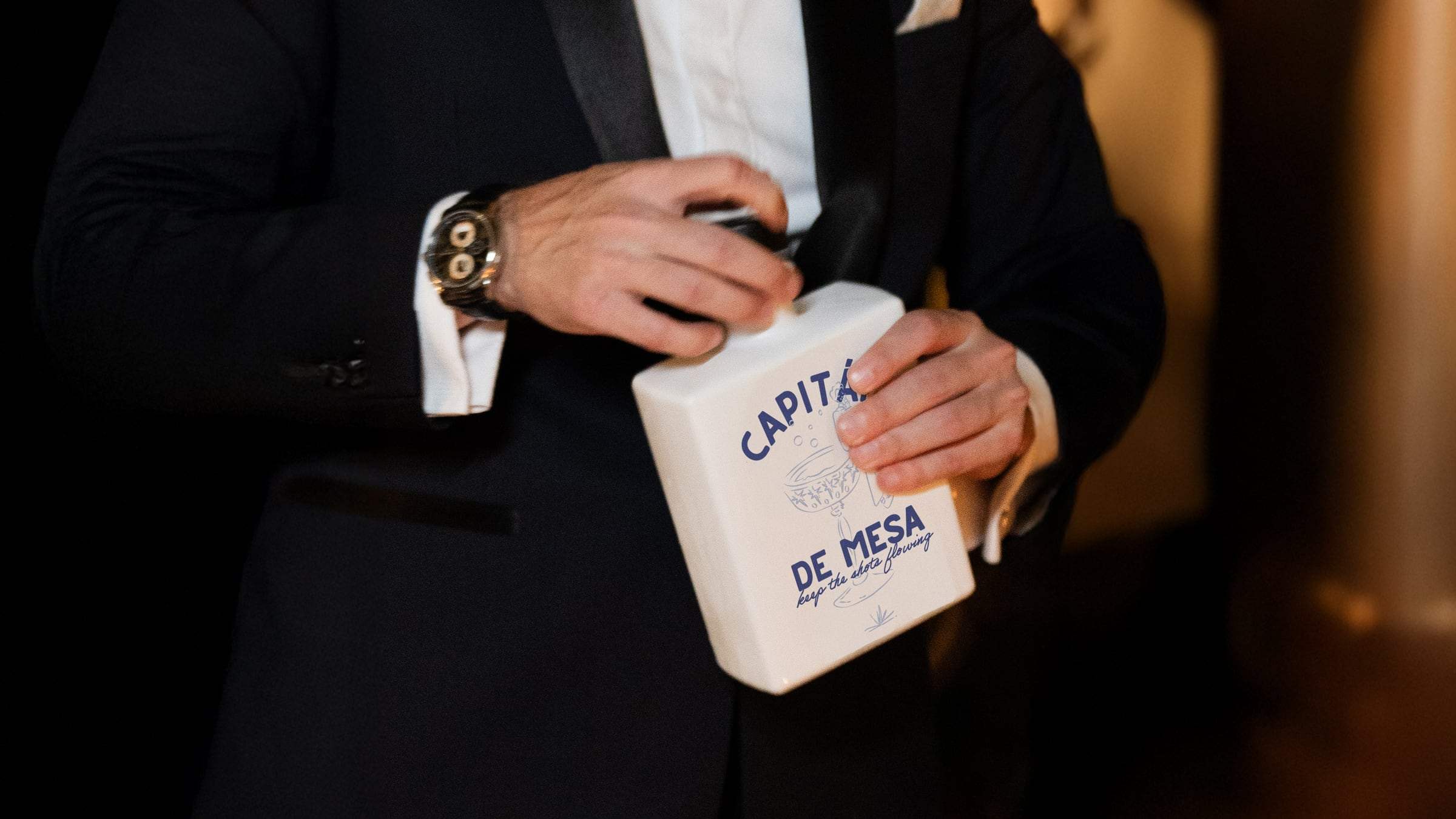 Invitado sosteniendo la botella Capitán de mesa durante la fiesta