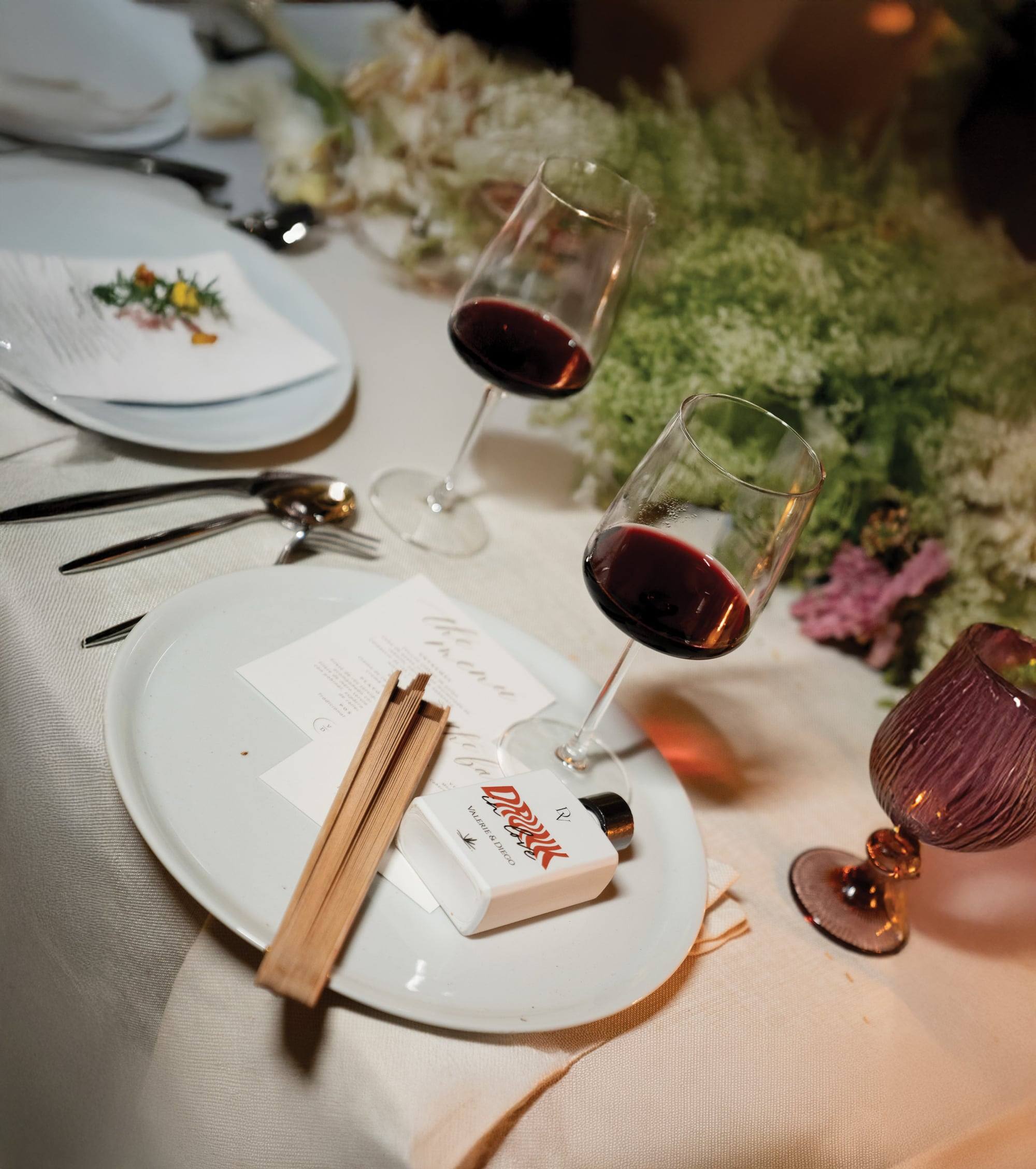 Botella personalizada sobre el plato, junto al menú y las copas de la mesa