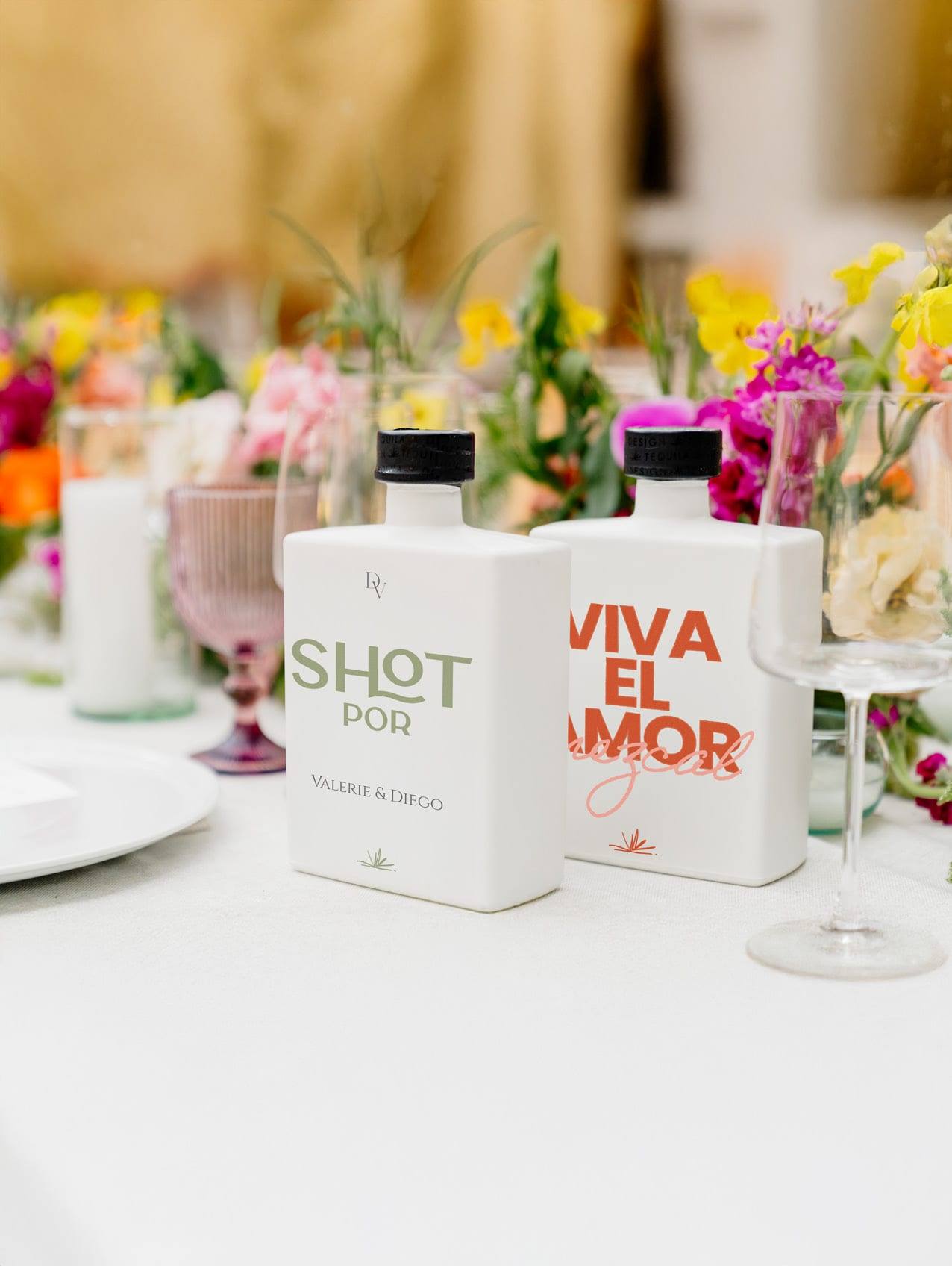 Botellas Master con los mensajes Shot por y Viva el amor sobre la mesa