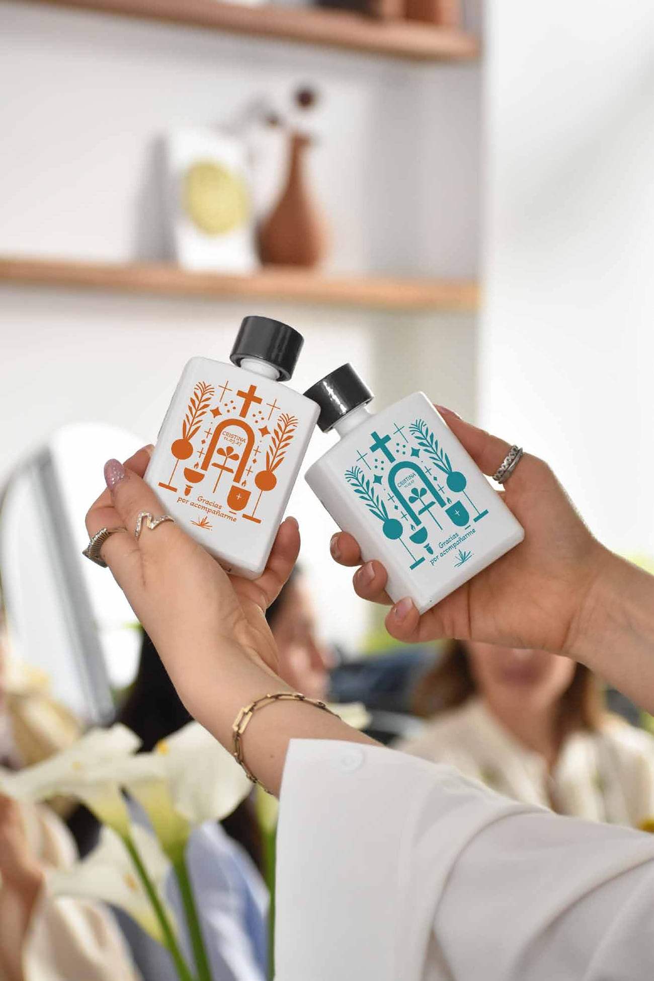 Dos invitadas sosteniendo botellas Pocket con ilustraciones a color
